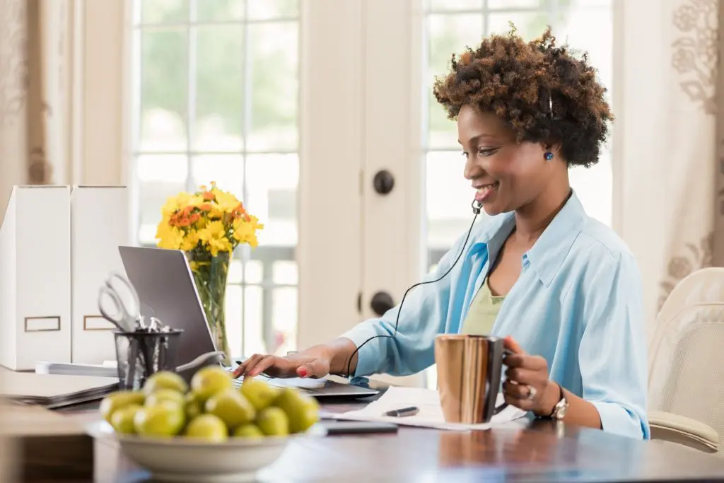 Image of person working from home with a headset on.