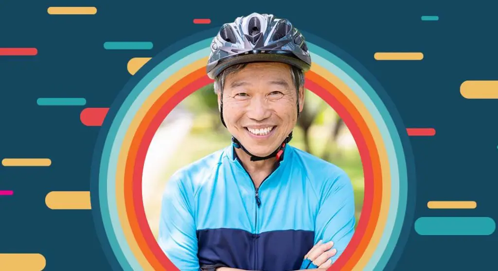 Image a person smiling wearing a bike helmet with bold multi color graphics behind them