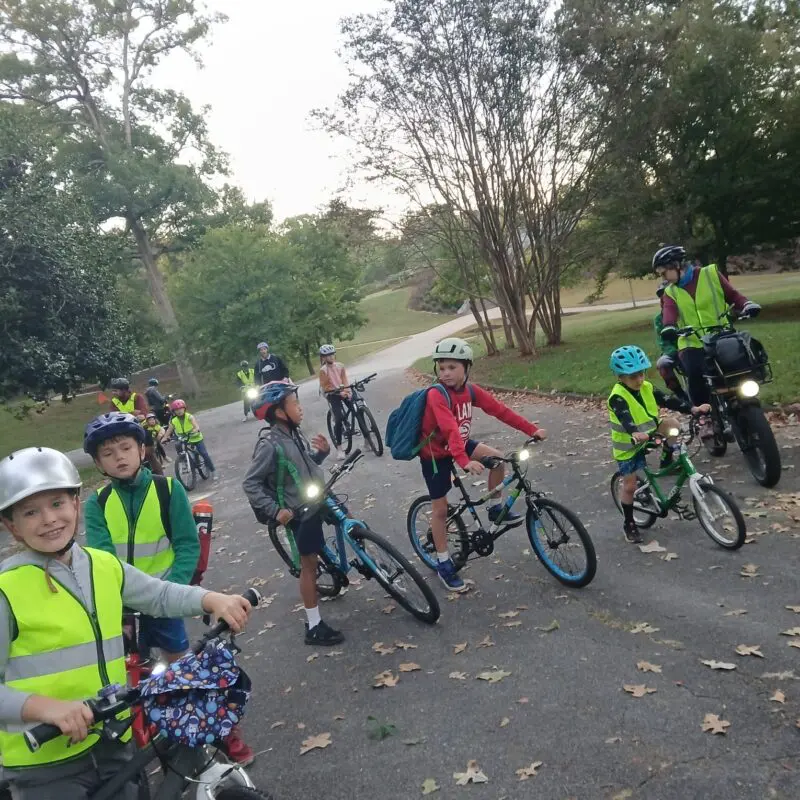 Multiple children and adults riding bicycles.