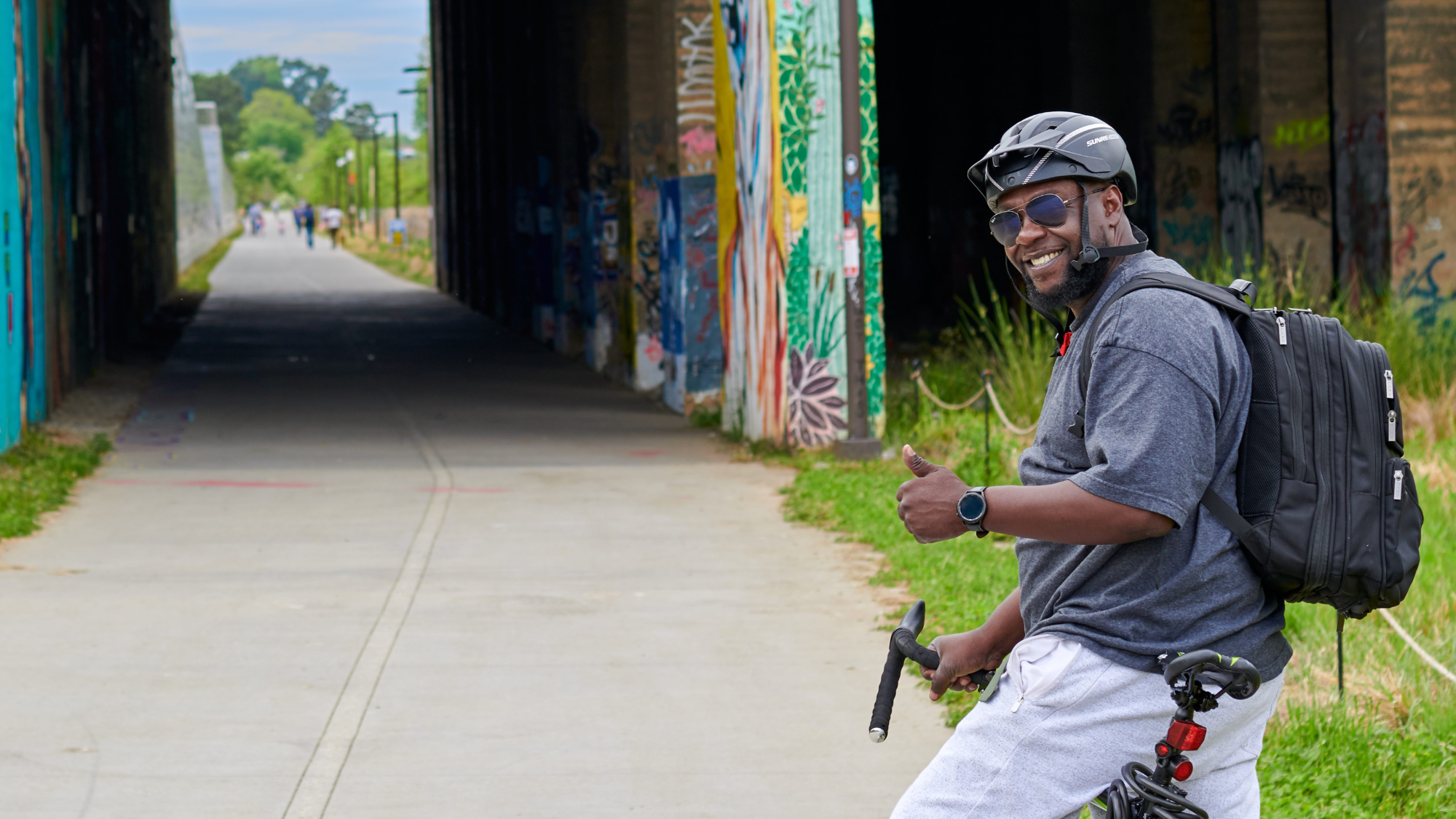 Person on a bicycle giving a thumbs up