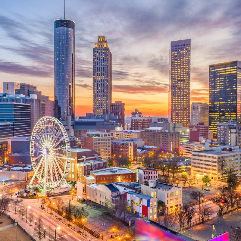 View of the Atlanta skyline with a view of a street, buildings and a Ferris wheel.