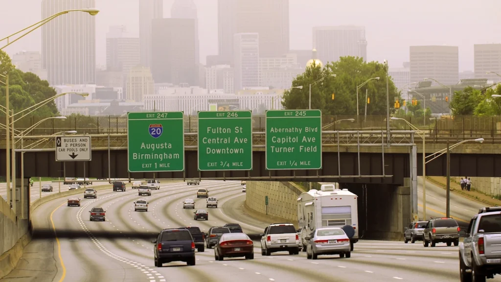 Photo of an Atlanta freeway, there are several cars going down the freeway.