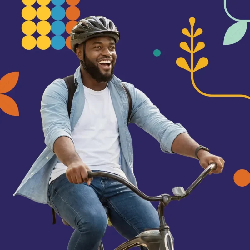 A smiling man wearing a helmet and backpack rides a bicycle against a dark blue background with colorful abstract shapes and leaves.