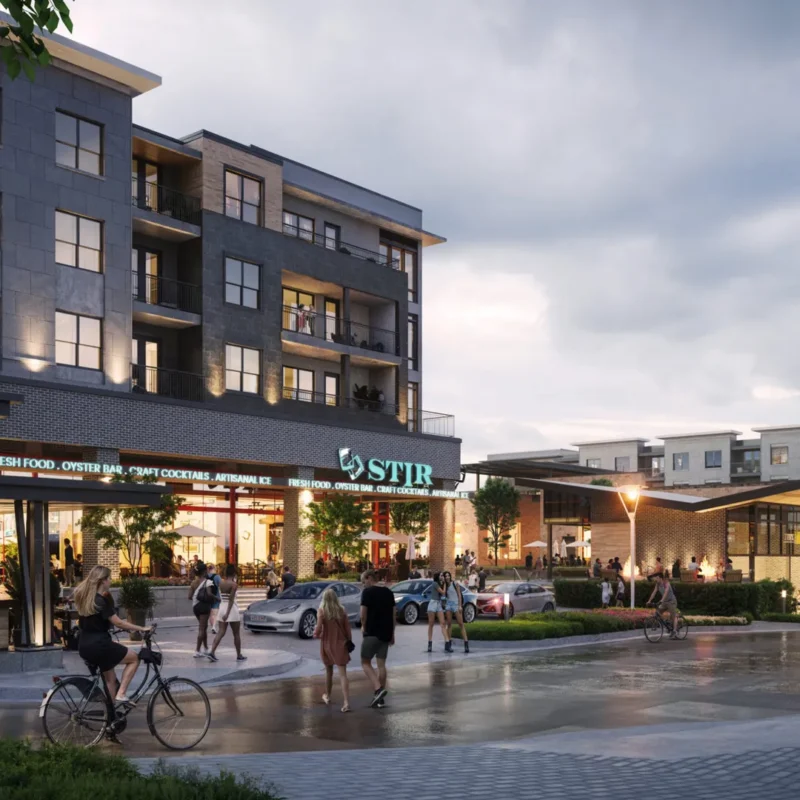 People walk and bike near modern apartment buildings and shops at dusk, with a restaurant called “STIR” visible, cars parked, and trees and lights adding to the lively, urban atmosphere.
