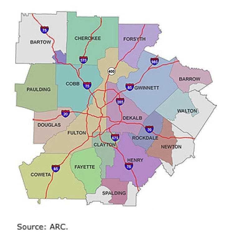 Map of the Atlanta metropolitan area showing color-coded counties, labeled with their names and intersected by red interstate highways.
